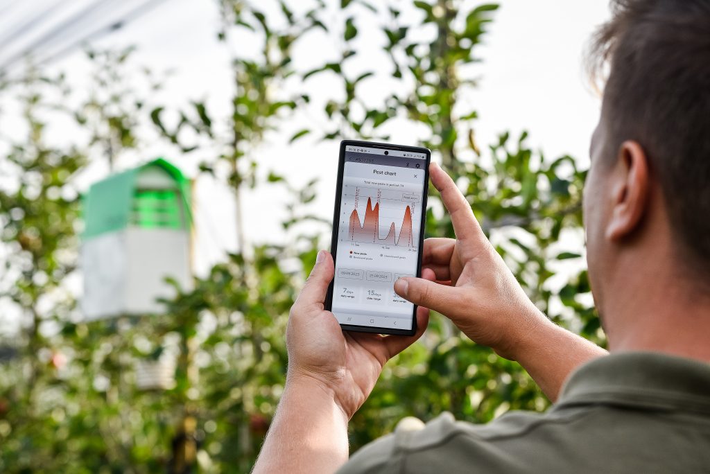 A person holding a phone that displays the Trapview Group's solution in action.