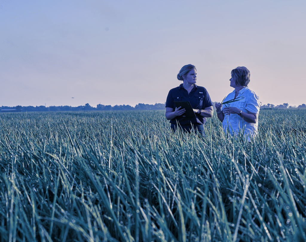 Two people discussing agriculture in a field